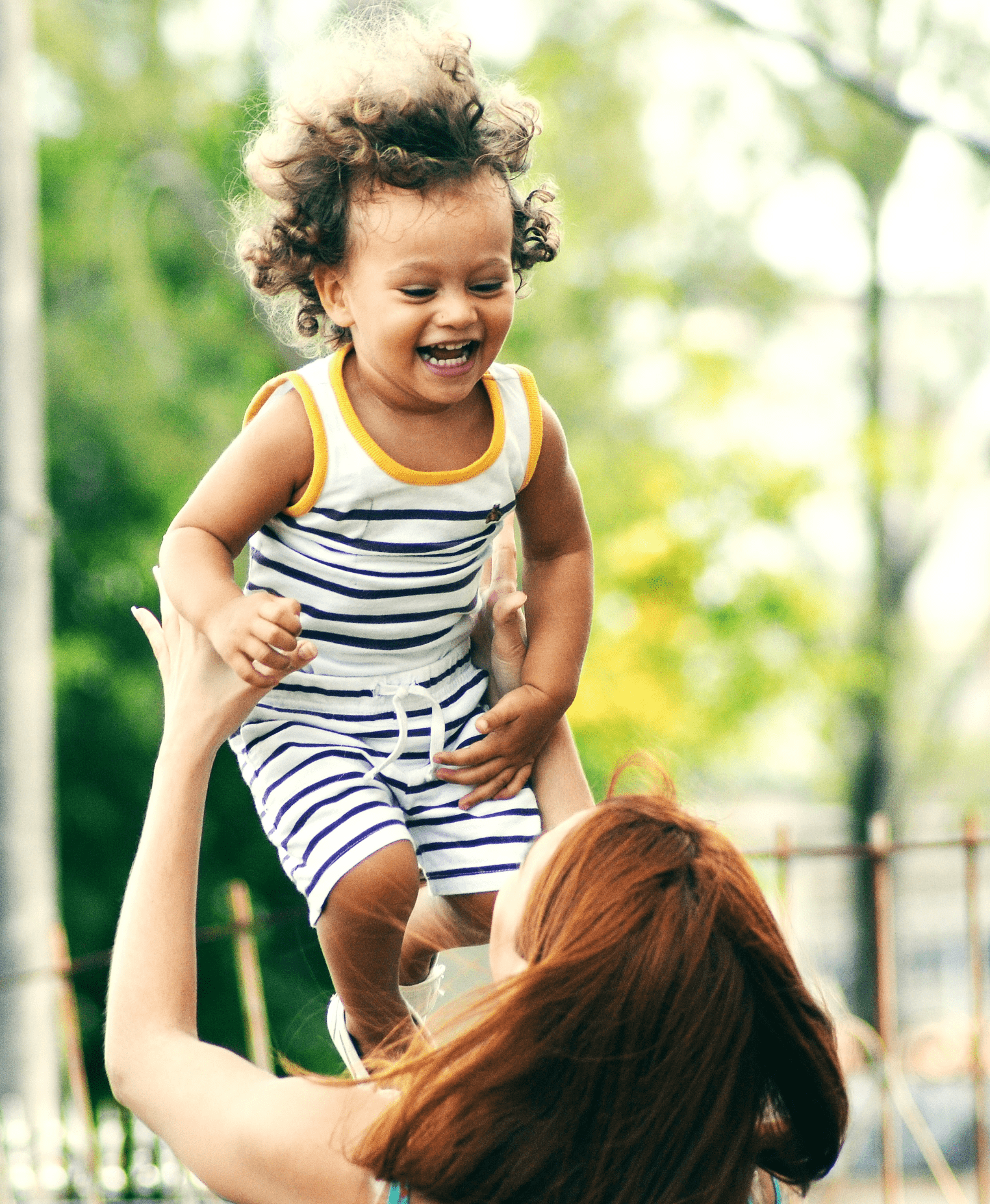 Uma mulher a brincar com uma criança sorridente